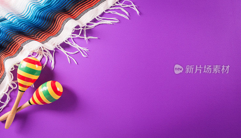 Cinco de Mayo假日背景由沙球，墨西哥毛毯条纹或雨披serape在紫色的背景。